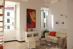 a living room with a couch and a painting on the wall at kaDevi piazza Bresca - pieno centro, parcheggio, bici in Sanremo