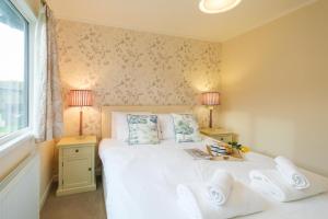 een slaapkamer met een bed met 2 lampen en een raam bij San Remo in Sizewell