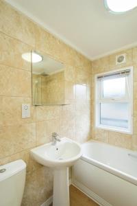 een badkamer met een wastafel en een bad bij San Remo in Sizewell