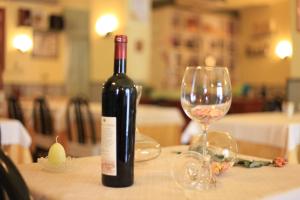 a bottle of wine and a glass on a table at Albergo Il Cochino in Montale