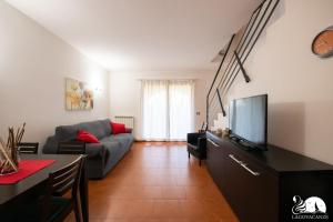 ein Wohnzimmer mit einem Sofa und einem TV in der Unterkunft Paraìso del Sol in Polpenazze del Garda