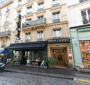 un edificio con mesas y sillas delante de él en Hotel 29 Lepic, en París