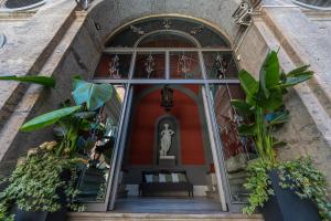 an entrance to a building with plants and a statue at Corte Satriano Residence in Naples