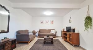sala de estar con 2 sofás y TV en SAMA Tarshiha en Ma'alot Tarshiha