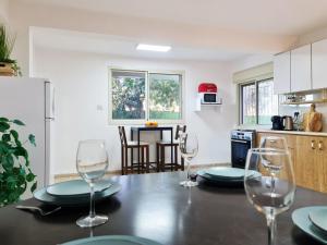 a kitchen with a table with wine glasses on it at SAMA Tarshiha in Ma'alot Tarshiha