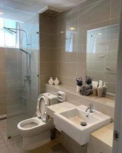 La salle de bains est pourvue de toilettes, d'un lavabo et d'une douche. dans l'établissement 2Bedroom Sutera Avenue Kota Kinabalu by Twen8ty Homestay, à Kota Kinabalu