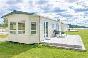 une petite maison avec une terrasse en herbe dans l'établissement KustCamp Gamleby, à Gamleby