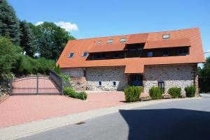 ein Gebäude mit einem orangenen Dach und einem Tor in der Unterkunft Glattbacher Hof in Lindenfels