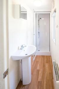 a white bathroom with a sink and a shower at KustCamp Gamleby in Gamleby