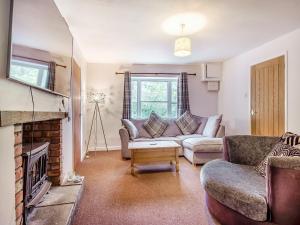 a living room with a couch and a fireplace at Harp Cottage in Brecon