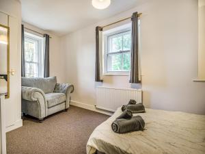 a bedroom with a bed and a couch and a chair at Harp Cottage in Brecon