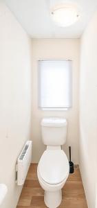 a bathroom with a white toilet and a window at KustCamp Gamleby in Gamleby