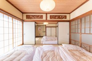 ein japanisches Schlafzimmer mit 2 Betten und einem Spiegel in der Unterkunft 樹蘭蕉 箱根仙石原 - JYURANSHO Hakonesengokuhara in Hakone