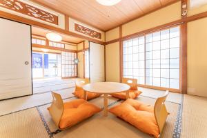 Habitación con mesa, sillas y ventanas. en 樹蘭蕉 箱根仙石原 - JYURANSHO Hakonesengokuhara en Hakone