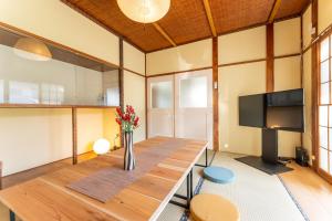 箱根樹蘭蕉 箱根仙石原 - JYURANSHO Hakonesengokuhara的配有桌子和平板电视的客厅