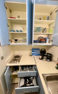 una cocina con armarios blancos y fregadero en KARMI Apartments Stenies Andros, en Steniaí