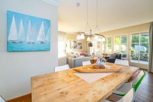 une salle à manger avec une table en bois et des voiliers sur le mur dans l'établissement Haus Syltzauber, à Keitum