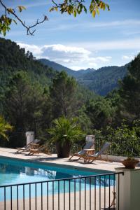 a pool with chairs and mountains in the background at Apartamentos Cortijo Peñardera in Siles