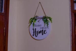 a home sweet home sign hanging on a wall at Lovely and homely 2 bedroom Serviced Apartment in Kilifi