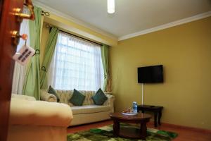sala de estar con sofá y ventana en Davis Court, en Nyeri