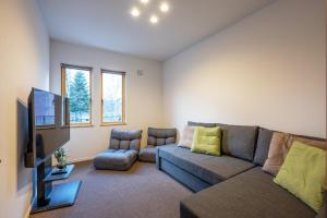 ein Wohnzimmer mit einem Sofa und einem TV in der Unterkunft RuPow Lodge - walking distance to Rusutsu Resort in Rusutsu