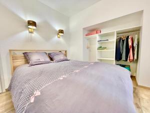 een slaapkamer met een groot bed met paarse lakens bij Colmar - Parking Gratuit - Le Nichoir - Centre historique - Wifi in Colmar