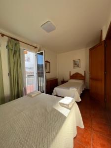 1 dormitorio con 2 camas y ventana en Hotel Los Cascajos, en San Nicolás