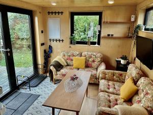 a living room with couches and a table in a caravan at Modernt Attefallshus in Ängelholm