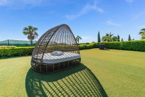 a bird cage sitting on the grass in a field at Villa Savoya Sunrise by Ezoria Villas in Coral Bay +30 photos