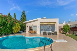 a swimming pool in front of a house at Villa Savoya Sunrise by Ezoria Villas in Coral Bay
