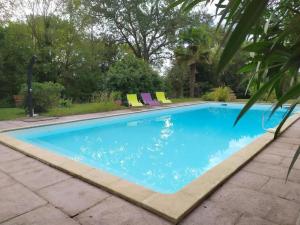 a swimming pool with blue water in a yard at Au chemin de Mazous in Laguian-Mazoux