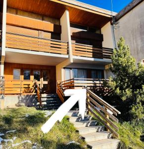 a house with a staircase in front of it at Rdc 48m2 avec terrasse Proche Centre avec parking privé couvert in Orcières