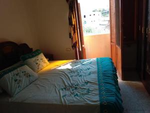 a bed sitting in a room with a window at Zekry nubian guest house in Aswan