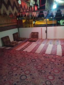 a room with two chairs and a rug at Zekry nubian guest house in Aswan