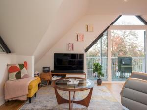 sala de estar con sofá, TV y mesa en Pass the Keys Stunning 7 Sleeper Penthouse on Windsor Riverside, en Windsor