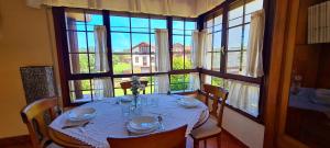 a dining room with a table and a large window at Las Parientucas in Novales