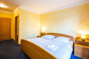 een slaapkamer met een bed met twee handdoeken erop bij Hotel Altstadt in Effeld