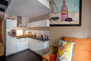 a kitchen with white cabinets and a bottle of wine on the wall at Residence City House De Rozenboom in Leeuwarden