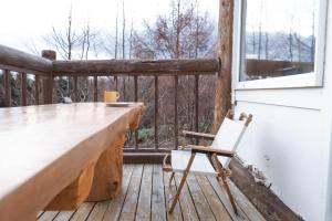 a porch with a desk and a chair on a deck at Woodhouse Yasunaya in Lake Toya