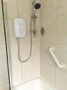 a shower with a shower head in a bathroom at 3-bedroom house with garden, conservatory, in centre of Worcester in Worcester