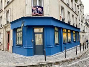 un bâtiment bleu sur le côté d'une rue dans l'établissement Logement GUÉNOT pour 5 personnes sur Paris 11, à Paris
