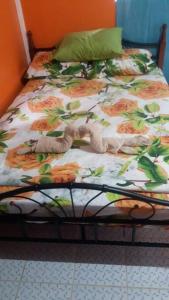 a bed with a floral comforter in a bedroom at Sunshine Apartment in Roger