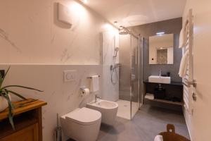 a bathroom with a toilet and a shower and a sink at Apartment Ando in Brunico