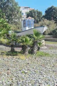 - un petit bateau assis au sommet d'une plage rocheuse dans l'établissement A un salto del mar WIFI, à La Mareta