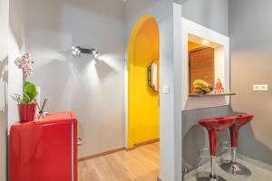 una stanza con una valigia rossa e una porta gialla di The HostMaster Hollywood Space Studio ad Atene