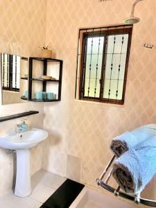 a bathroom with a sink and a mirror at Bungalow x Garten & Terrasse x WLAN x europäisch in Moshi