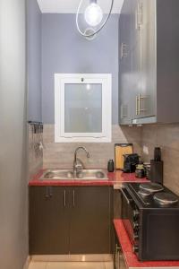 una cucina con lavello e fornello di The HostMaster Hollywood Space Studio ad Atene