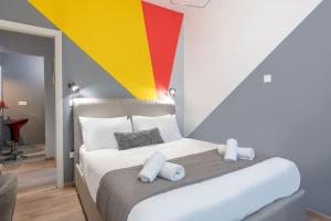 una camera da letto con un letto con una parete colorata di The HostMaster Hollywood Space Studio ad Atene Altre 9 foto