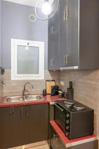 una cucina con lavello e fornello di The HostMaster Hollywood Space Studio ad Atene
