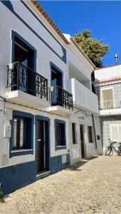 a blue and white building with a balcony at The Doll’s House in Tavira